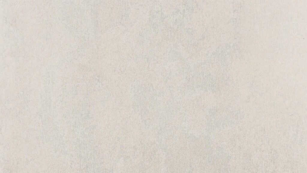 A close-up view of a plain, light beige textured surface. The texture is subtle, with faint variations in shade creating a slightly uneven, natural appearance. The overall tone is soft and neutral.