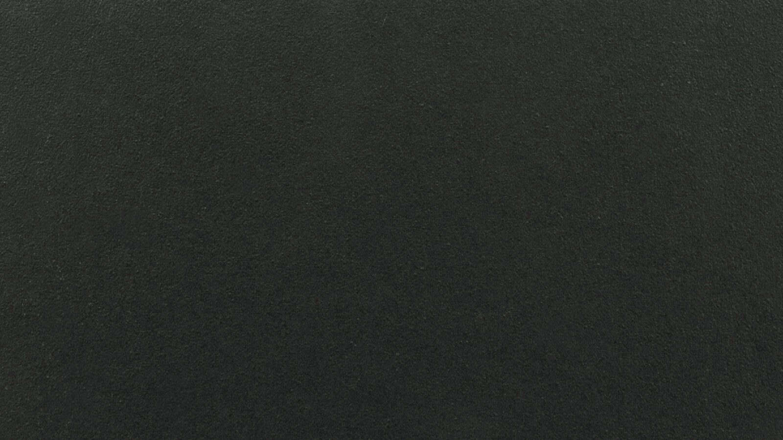 A close-up view of a dark textured surface, possibly black or very dark gray. The texture appears uniform and slightly rough, resembling materials such as asphalt, concrete, or a chalkboard.